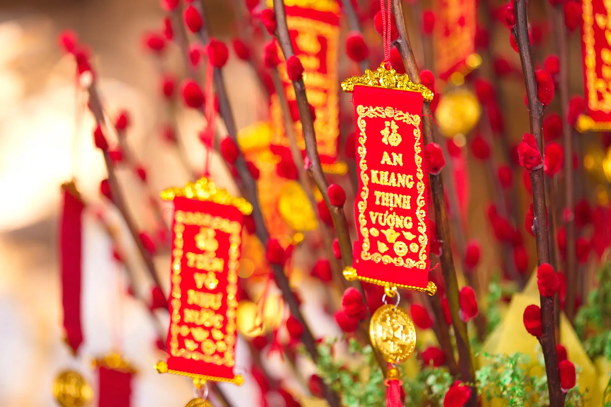 Pussy willow branches dyed red and hung with red and gold Lunar New Year charms